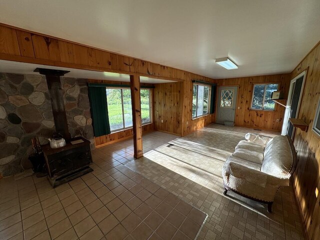 5490 S Harrison Rd, Houghton Lake, MI 48629 - living area featuring a wood stove and wooden walls