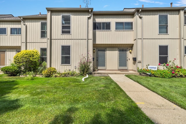 townhome / multi-family property featuring a front lawn