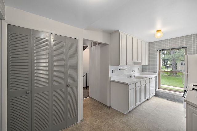 kitchen featuring white cabinets, backsplash, white appliances, and sink