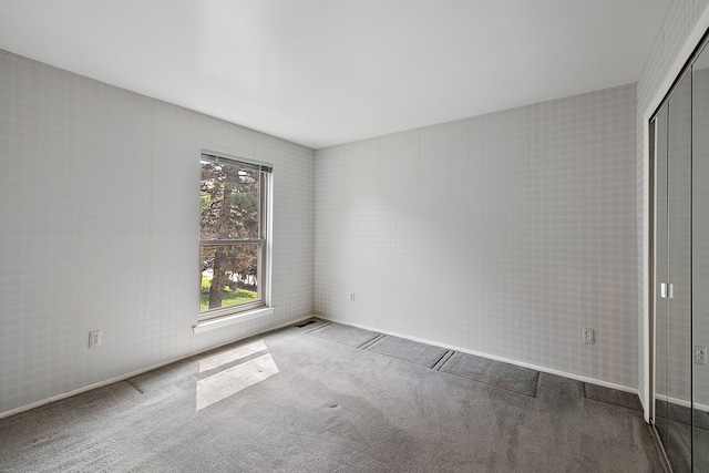 unfurnished bedroom featuring light carpet and a closet