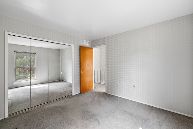 unfurnished bedroom featuring carpet flooring and a closet