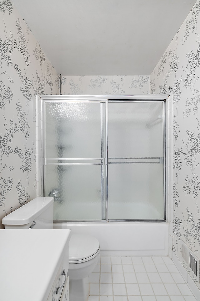 full bathroom with tile patterned flooring, vanity, bath / shower combo with glass door, and toilet