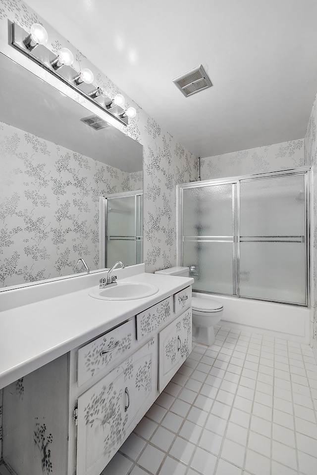 full bathroom featuring shower / bath combination with glass door, tile patterned floors, vanity, and toilet