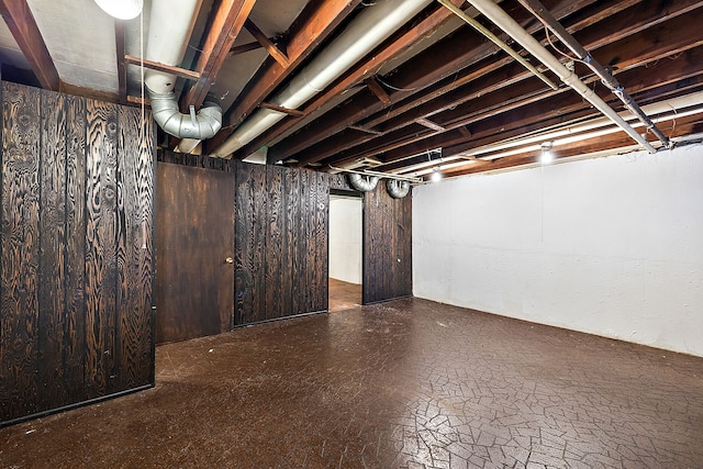 basement featuring wood walls