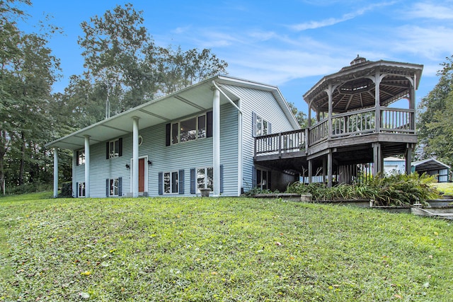 rear view of house featuring a gazebo and a yard