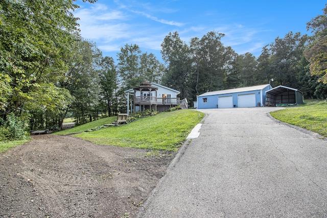 view of front of home featuring a deck, a carport, an outdoor structure, a front yard, and a garage