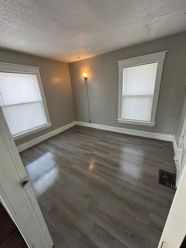 1408 E Main St, Kalamazoo, MI 49048 - spare room featuring a textured ceiling, baseboards, and dark wood-type flooring