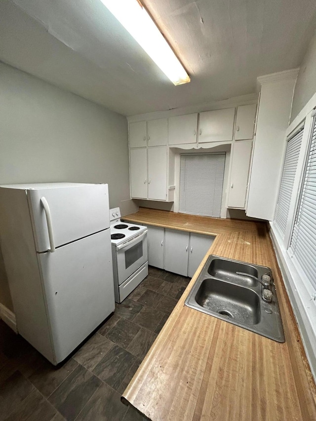 kitchen with sink, white cabinets, and white appliances