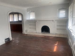 unfurnished living room with dark hardwood / wood-style floors