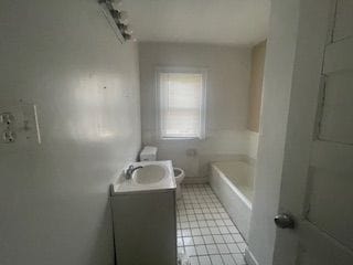 bathroom with vanity, toilet, and a tub