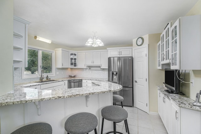 29100 Heritage Ln, Paw Paw, MI 49079 - kitchen featuring appliances with stainless steel finishes, a peninsula, a chandelier, and decorative backsplash