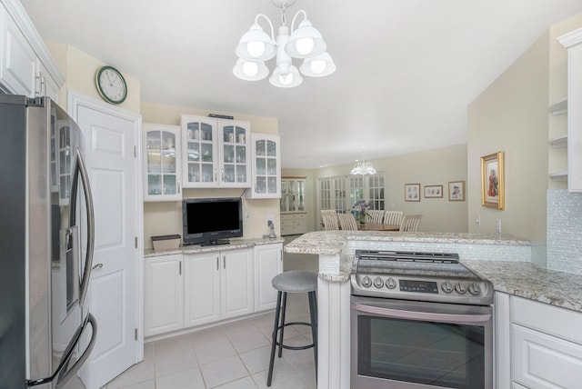 kitchen with white cabinets, stainless steel appliances, kitchen peninsula, and hanging light fixtures