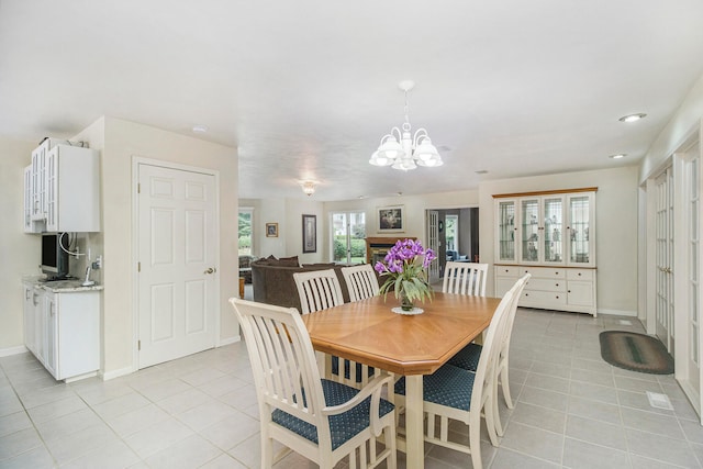 dining space with light tile patterned floors and an inviting chandelier