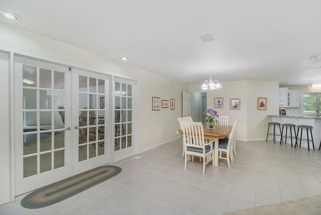 tiled dining room with french doors and an inviting chandelier