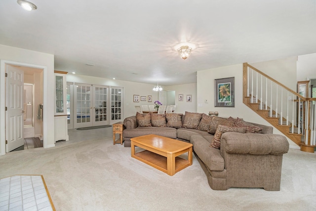 living room with a chandelier, french doors, and light colored carpet