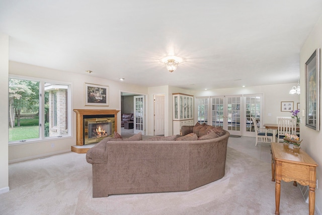 living room with french doors, light colored carpet, and an inviting chandelier