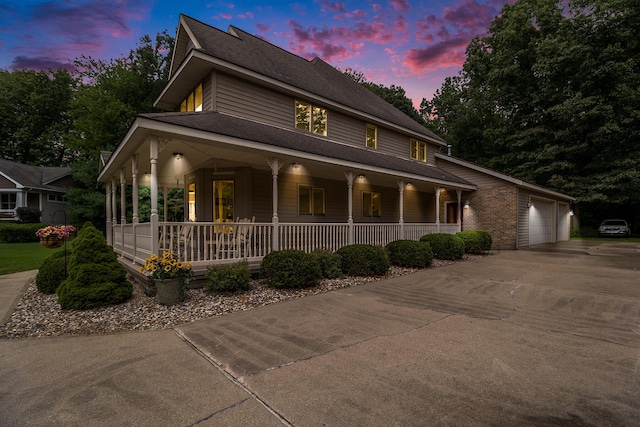 29100 Heritage Ln, Paw Paw, MI 49079 - farmhouse-style home with covered porch, concrete driveway, an attached garage, and a shingled roof