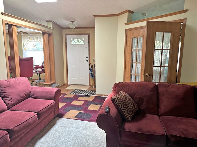 living room featuring crown molding, a textured ceiling, and french doors