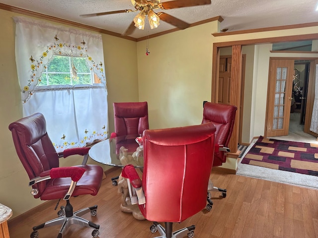 dining room featuring ornamental molding, ceiling fan, a textured ceiling, and light hardwood / wood-style flooring