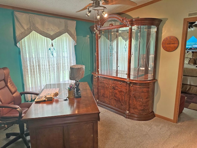 carpeted office featuring crown molding, a textured ceiling, and ceiling fan