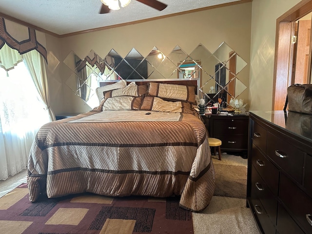 bedroom featuring ceiling fan, crown molding, carpet floors, and a textured ceiling