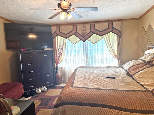 bedroom with ceiling fan, ornamental molding, and a textured ceiling