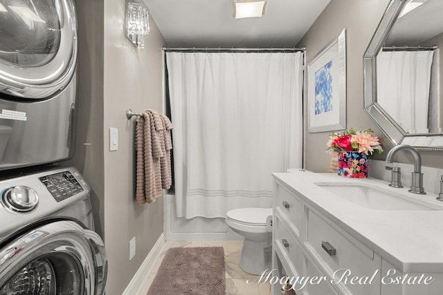 bathroom featuring tile patterned floors, vanity, toilet, and stacked washer / drying machine