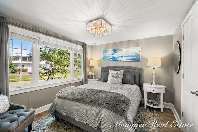 bedroom with wood-type flooring and a notable chandelier