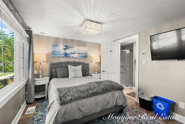 bedroom featuring a chandelier, dark hardwood / wood-style flooring, and multiple windows