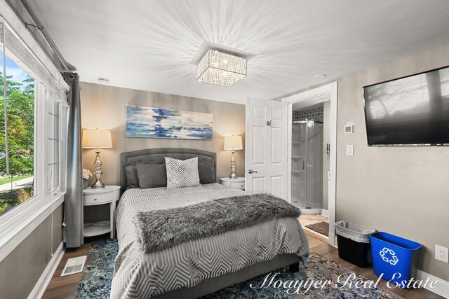 15 E Wall St, Douglas, MI 49406 - bedroom featuring wood finished floors, baseboards, and a chandelier