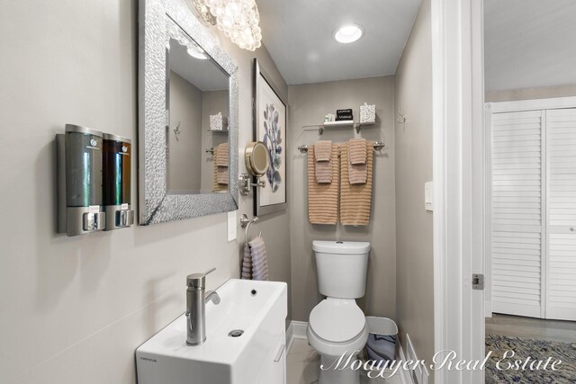 15 E Wall St, Douglas, MI 49406 - bathroom with toilet, a closet, baseboards, and wood finished floors