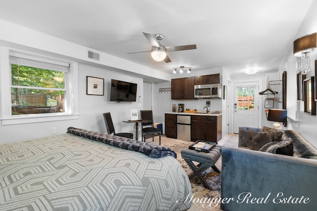 living room featuring ceiling fan and sink