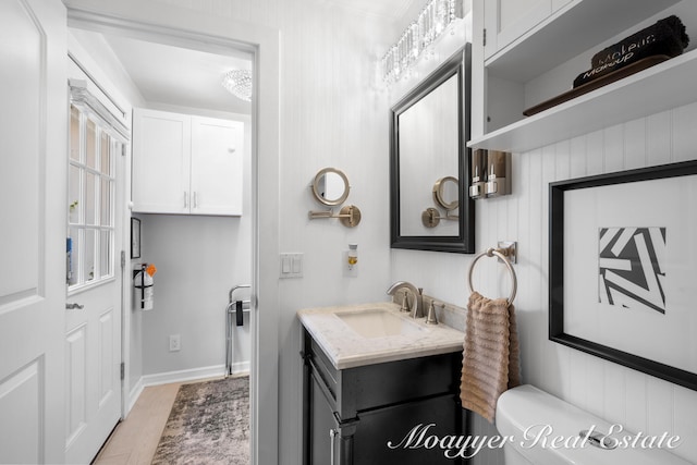 bathroom with wood-type flooring, vanity, and toilet