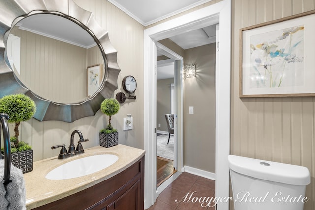 bathroom with toilet, vanity, tile patterned floors, and ornamental molding