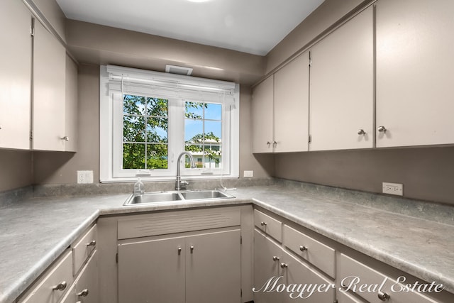 kitchen featuring white cabinetry and sink