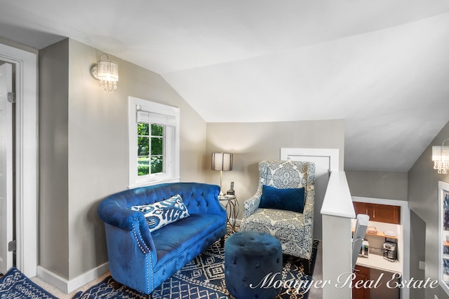 living area featuring vaulted ceiling and a notable chandelier