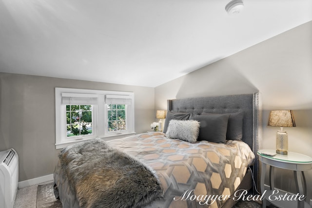 carpeted bedroom with lofted ceiling