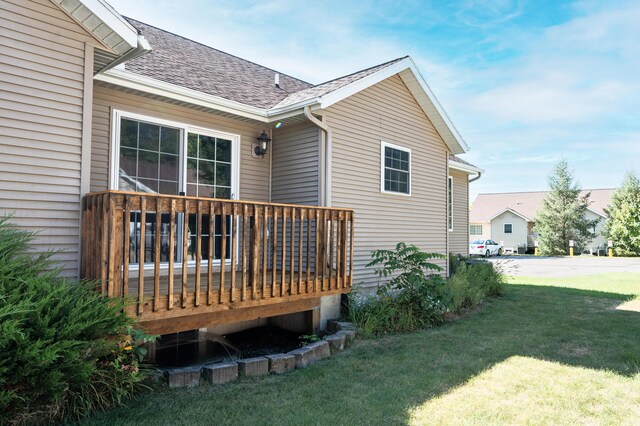 722 Tioga Park Unit 722, Big Rapids, MI 49307 - back of house with a shingled roof, a wooden deck, and a yard