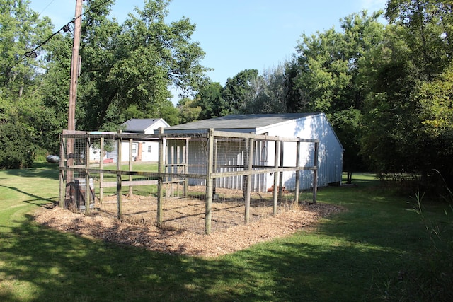 back of house with a lawn and an outbuilding