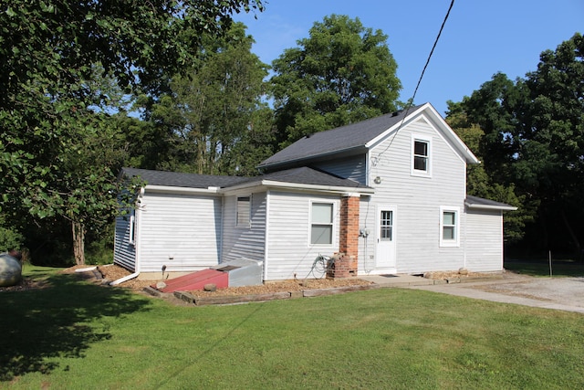 rear view of property featuring a yard