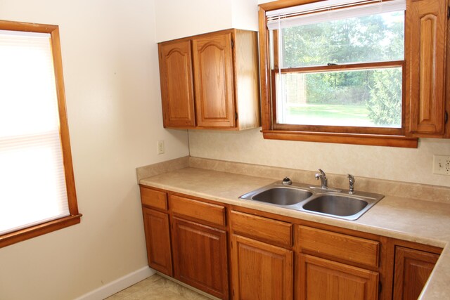 kitchen featuring light tile patterned floors and sink