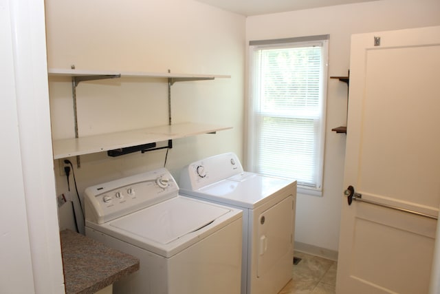 laundry room featuring washing machine and dryer and light tile patterned flooring