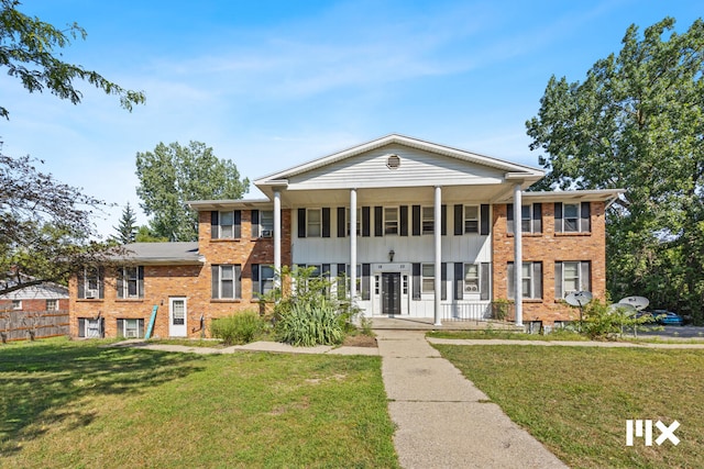 neoclassical home featuring a front lawn