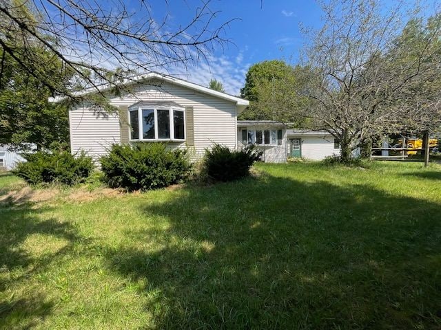 view of side of home with a yard