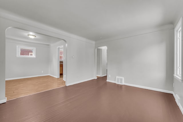 empty room with a wealth of natural light and wood-type flooring