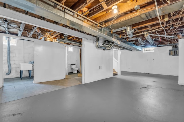 basement featuring electric panel and sink