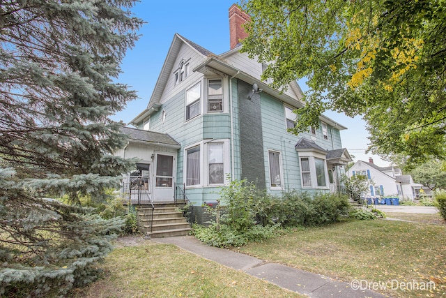 victorian home with a front lawn