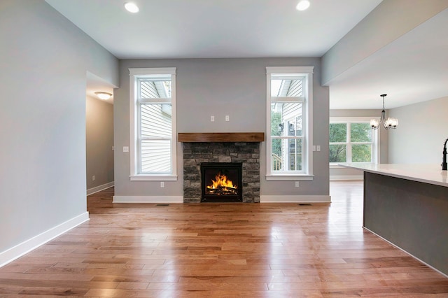 unfurnished living room with a fireplace, light hardwood / wood-style flooring, and a wealth of natural light