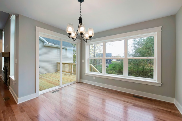 unfurnished dining area with hardwood / wood-style flooring and an inviting chandelier