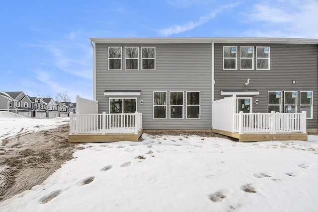 snow covered house featuring a deck